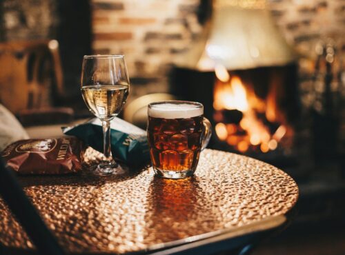 clear drinking glass with brown liquid on brown wooden table